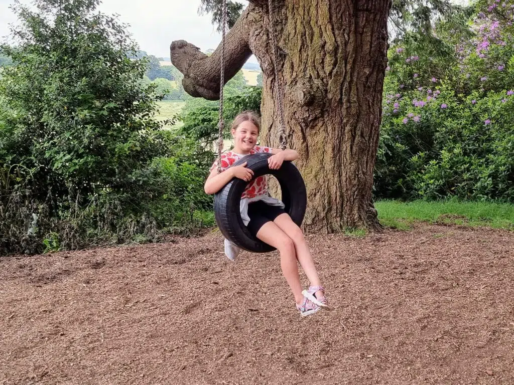 How to home educate on a budget, UK discounts, freebies & tips for travel, resources & days out guide, photo of frugal mum child on swing