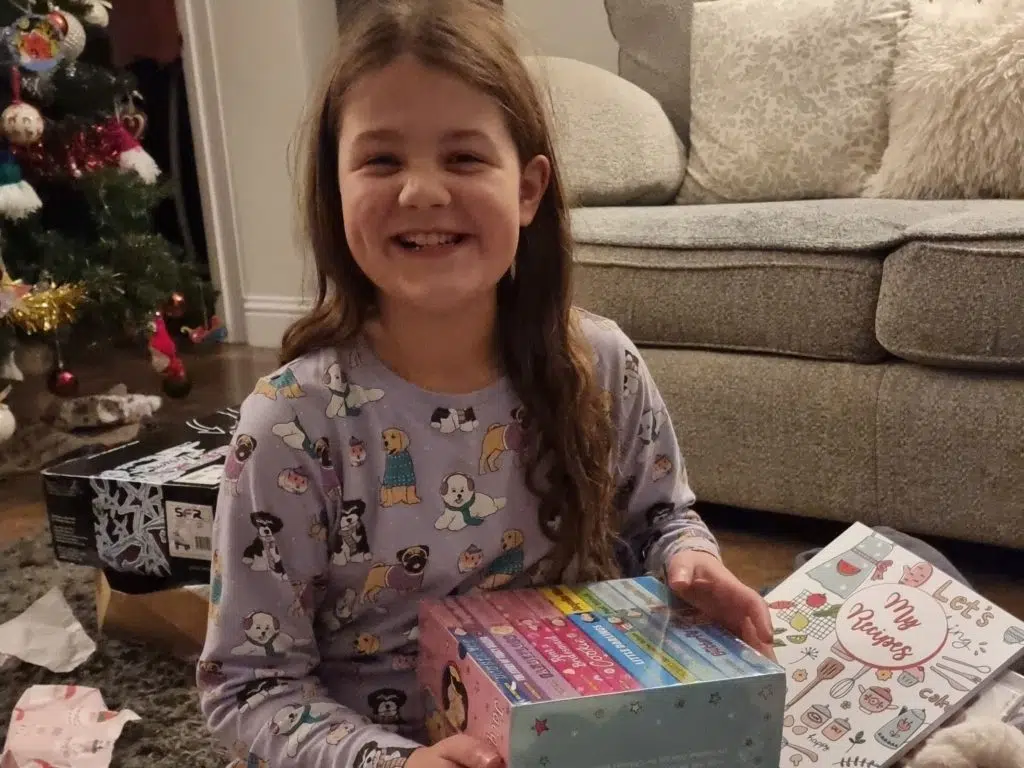 Christmas without money: 30 tips for a DIY budget family Christmas, frugal mum child unwrapping christmas gift
