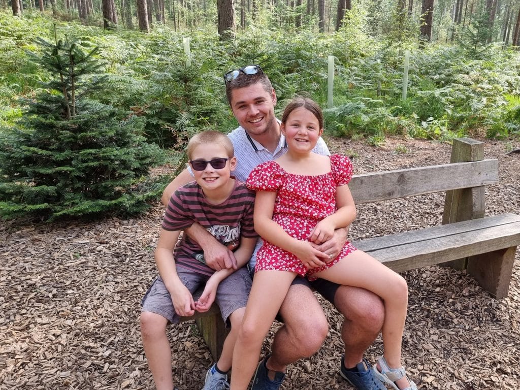The Ultimate Guide to visiting Moors Valley Country Park with kids, frugal mum travel guide, photo of family on bench