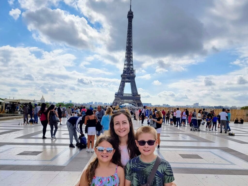 Where to Stay in Paris with Kids, frugal mum travel guide, image of family by eiffel tower