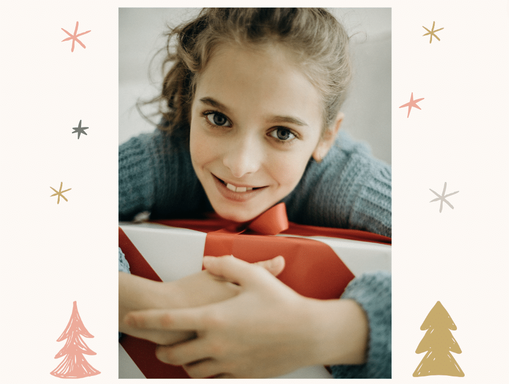 child smiling with christmas gift, Where to donate (or receive) children's charity Christmas gifts in the UK, frugal mum guide
