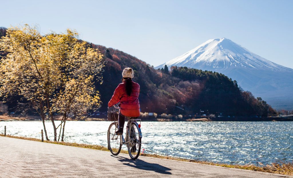 lady riding bike by the water, frugal fun, embracing simple lifestyle, free exercise