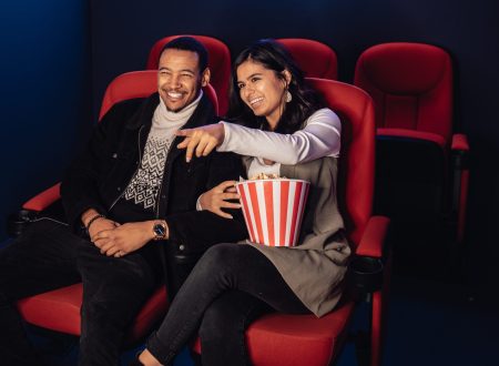 couple smiling, watching movie, popcorn, cinema
