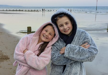 frugal mum children at beach in dressing gowns, evening swim