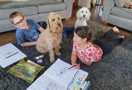 children doing school work on floor with dogs, home education, frugal mum