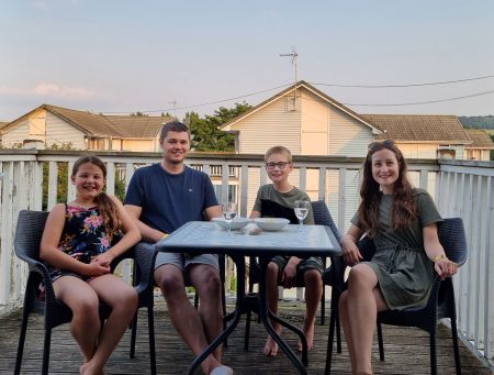 frugal mum family holiday photo on balcony with children sitting at table